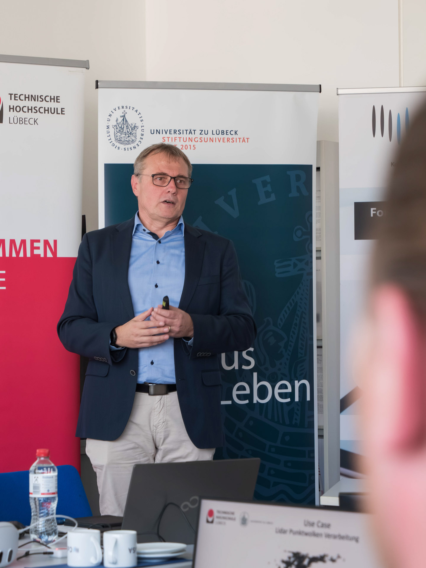 Ein Mann steht vor einem RollUp der Universität zu Lübeck